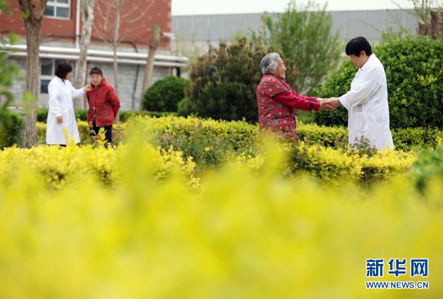 在河北省衡水市桃城区一家养老康复医疗中心,护工在陪老人散步(2019年5月5日摄)。新华社记者 牟宇 摄